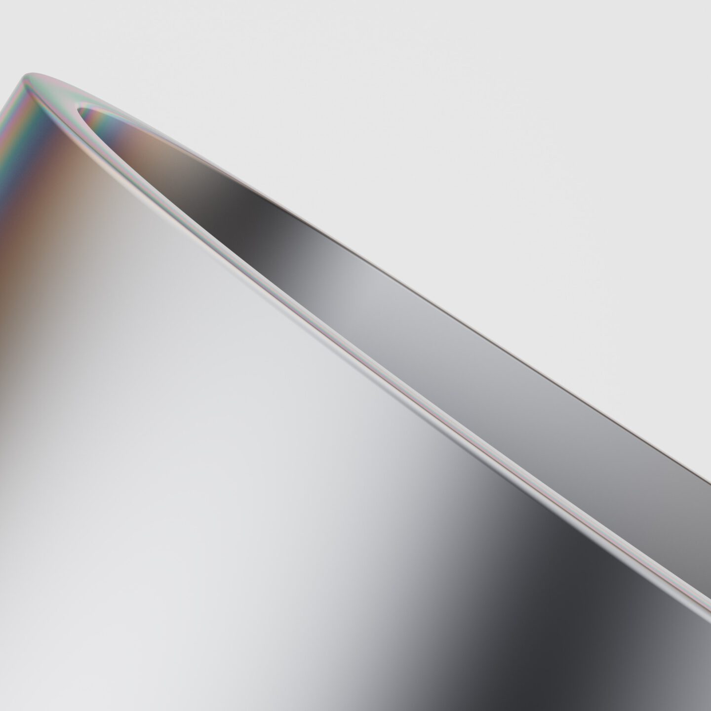 Close-up image of a sleek, curved metallic surface against a plain white background. The surface has a reflective, shiny finish, and a faint prism of colors is visible along the edge, giving it a futuristic and minimalistic appearance.